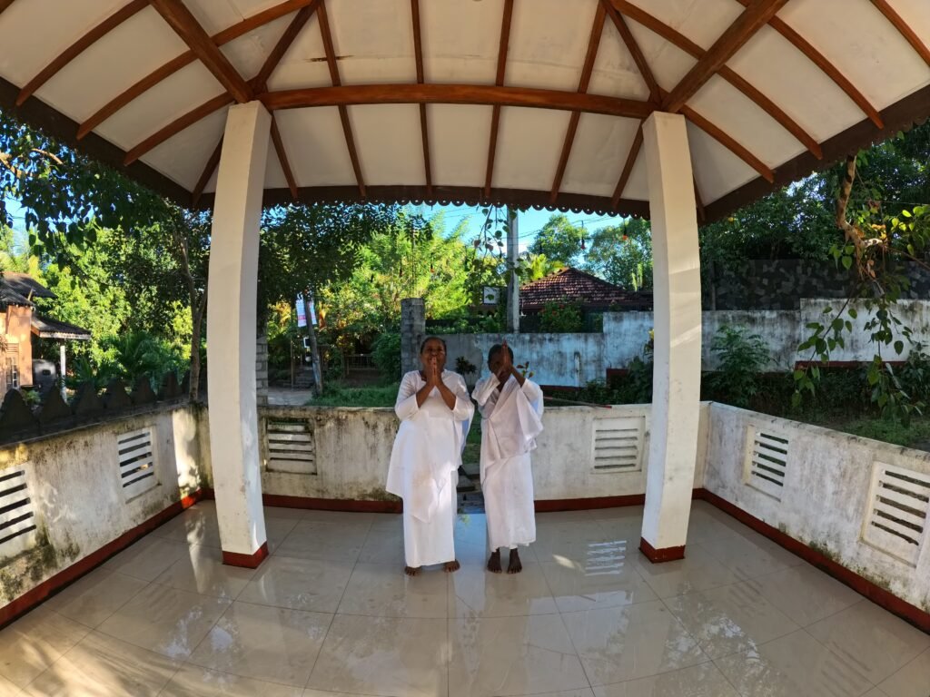 Two women in white standing under a pavilion in southern Sri Lanka