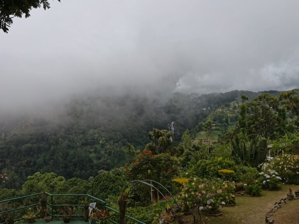 Ella disappearing into the clouds. Clouds over the green hills and a waterfall near Ella, Sri Lanka